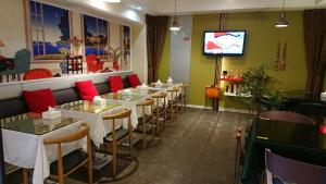 a restaurant with a row of tables and a television at 高第商旅 Gaudi Hotel in Kaohsiung