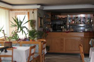 a dining room with a bar with a table and a table sidx sidx at Garnì Goccia d'Oro in Cavalese