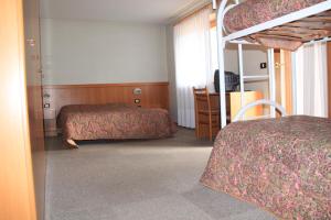 a bedroom with two beds and a bunk bed at Garnì Goccia d'Oro in Cavalese