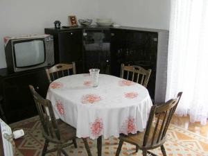 a table with a white table cloth and a tv at Apartment Pasman 1 in Pašman