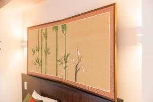 a large painting of palm trees on a wall at Kyoto Inn Gion The Second in Kyoto