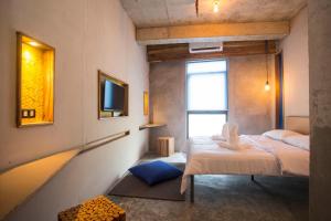 a small room with two beds and a window at Frendz Hostel El Nido in El Nido