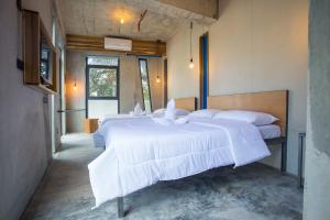 a bedroom with two beds with white sheets at Frendz Hostel El Nido in El Nido
