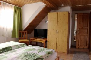 a bedroom with a bed and a desk with a television at Pension WoGi in Wolfegg