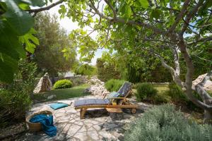a garden with a bench and a chair on a path at Villa Pag in Mandre