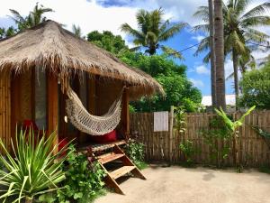een hut met een hangmat en een hek bij Rumah Canaria Bungalow in Gili Trawangan