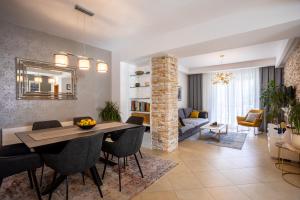 a dining room and living room with a table and chairs at Pansion Tina in Šilo