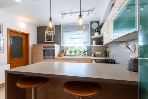a kitchen with a large counter and two stools at Pansion Tina in Šilo