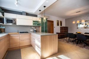 a kitchen with white cabinets and a dining room with a table at Pansion Tina in Šilo