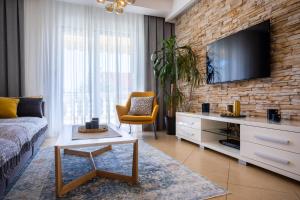 a living room with a couch and a tv on a brick wall at Pansion Tina in Šilo