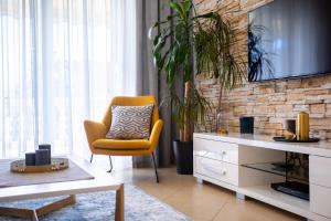 a living room with a yellow chair and a tv at Pansion Tina in Šilo