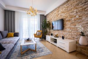 a living room with a couch and a brick wall at Pansion Tina in Šilo