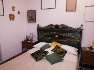Schlafzimmer mit einem Bett mit einem grünen Kopfteil und Kissen in der Unterkunft Residenza Rubbiani - Fermata Fiera e Rizzoli in Bologna