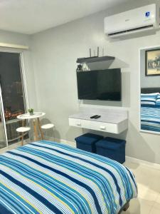sypialnia z łóżkiem i telewizorem z płaskim ekranem w obiekcie Explorer Suite 1004 w mieście Bacolod
