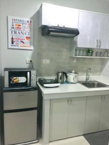 a small kitchen with a sink and a microwave at Explorer Suite 1004 in Bacolod