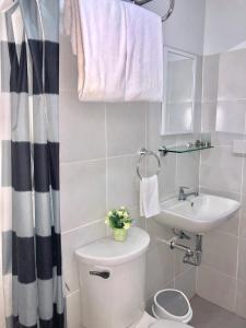 biała łazienka z toaletą i umywalką w obiekcie Explorer Suite 1004 w mieście Bacolod