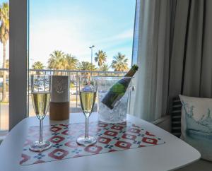 a bottle of champagne and two glasses on a table at Hôtel Josse in Antibes