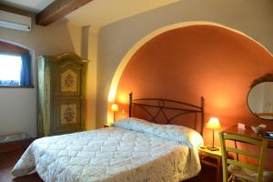 a bedroom with a bed and an orange wall at B&B La corte di Stelio in Pisa