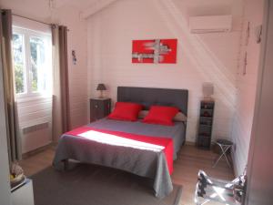 フィガリにあるChambres La Falcia - Figari - Corse Du Sudのベッドルーム1室(赤い枕と壁のクロス付)