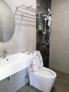 a bathroom with a white toilet and a sink at One Plus One Boutique Residence in Kuantan