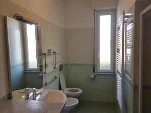 bagno con lavandino, servizi igienici e finestre di Appartamento Azalea a Levanto