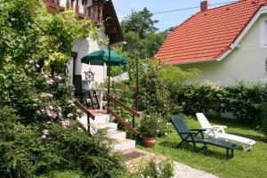 バラトンギュルクにあるHoliday home in Vonyarcvashegy 20268の庭園内のパティオ(椅子、パラソル付)