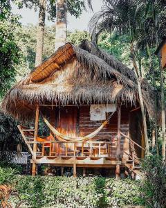 a straw hut with a hammock in front of it at LITTLE EDEN Bungalows in Ko Chang
