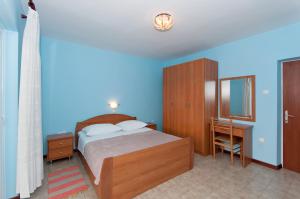 a bedroom with a bed and a blue wall at Apartment Lopar 12 in Lopar
