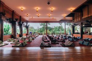 a large room with lounge chairs and large windows at Sasidara Resort Nan in Nan