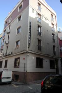 un grand bâtiment blanc au coin d'une rue dans l'établissement Sheriff Residence, à Istanbul