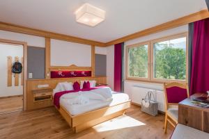 um quarto com uma cama grande e cortinas roxas em Hotel Rösslhof em Ramsau am Dachstein mais 65 fotografias