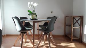 a dining room table with chairs and a vase on it at "Bindergor-Hof" Georg Barbieri in Terlano