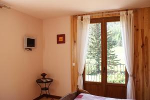 a bedroom with a bed and a sliding glass door at Maison d' hôtes Tranquyl in Barcelonnette