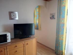 a living room with a tv on top of a dresser at Appartement Helga in Goldegg