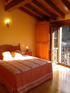 een slaapkamer met een bed en een groot raam bij Casa Rural LA HUERTA DE POTES in Cabezón de Liébana