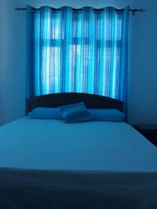 a blue bedroom with a bed with a blue light at Studio Ametisse in Belle Mare