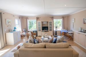 a living room with a couch and a kitchen at The Holliday Pad in Plettenberg Bay