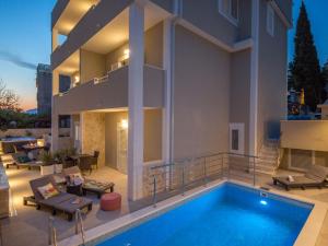 a house with a swimming pool in front of it at Apartment Villa Franko Maris in Podstrana