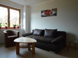 a living room with a black couch and a table at Modern Apartment in Eifel near Forest in Dohm-Lammersdorf