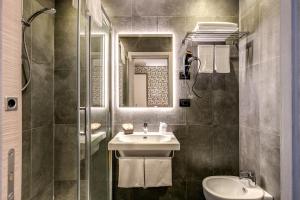La salle de bains est pourvue d'un lavabo, de toilettes et d'un miroir. dans l'établissement Colosseo Prestige Rooms, à Rome 17 autres photos