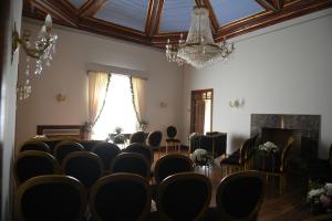 Zimmer mit Stühlen, einem Tisch und einem Kronleuchter in der Unterkunft Palacio São Silvestre-Boutique Hotel in Coimbra