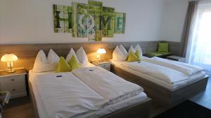 two beds in a hotel room with two lamps at Hotel Deutschherrenhof in Trier