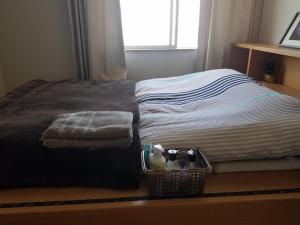 宮崎市にあるOcean Home Guest Houseのベッドルーム1室(ベッド1台、靴のバスケット付)