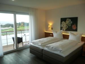 um quarto com uma cama grande e uma varanda em Gasthof Brennerei zum Forst em Kressbronn am Bodensee mais 38 fotografias