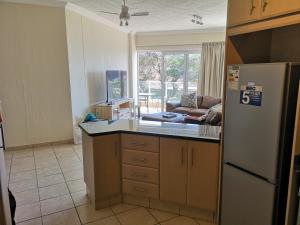a kitchen with a refrigerator and a counter top at Seahorse unit 4 in Scottburgh