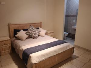 a bedroom with a bed with pillows and a bathroom at Seahorse unit 4 in Scottburgh +57 photos