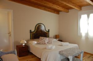 a bedroom with two beds and a wooden ceiling at Agriturismo L'Aglientu B&B in Loiri