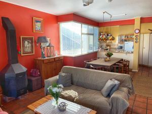 a living room with a couch and a stove at Toms Cabin in Herolds Bay