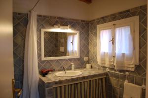 a bathroom with a sink and a mirror at Agriturismo L'Aglientu B&B in Loiri