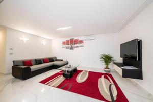 a living room with a couch and a red rug at VILLA LIDIA in Mundanije